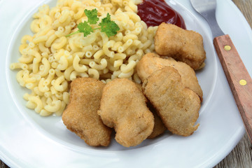 plate of chicken nuggets and coquillettes pasta