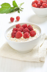Tasty oatmeal porridge with raspberries in bowl
