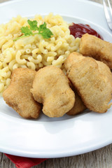 plate of chicken nuggets and coquillettes pasta