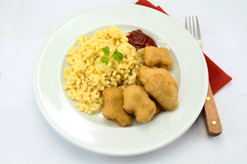 plate of chicken nuggets and coquillettes pasta