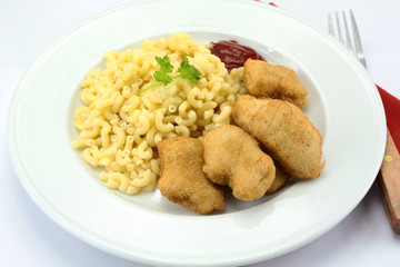 plate of chicken nuggets and coquillettes pasta
