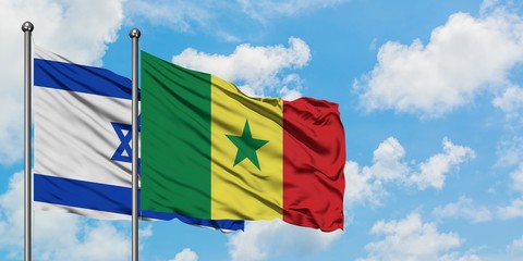 Israel and Senegal flag waving in the wind against white cloudy blue sky together. Diplomacy concept, international relations.