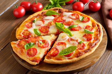 Sliced pizza Margarita on wooden table