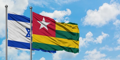 Israel and Togo flag waving in the wind against white cloudy blue sky together. Diplomacy concept, international relations.