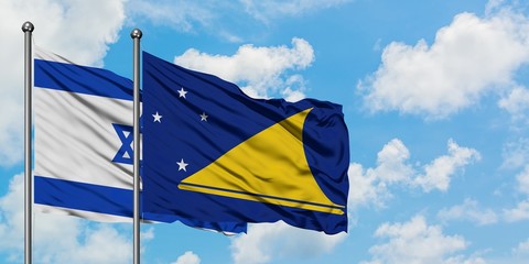 Israel and Tokelau flag waving in the wind against white cloudy blue sky together. Diplomacy concept, international relations.