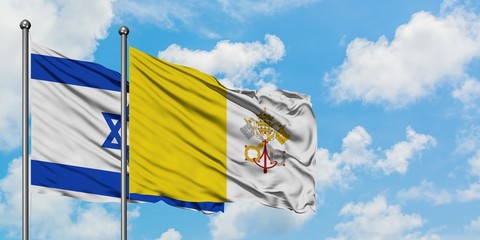 Israel and Vatican City flag waving in the wind against white cloudy blue sky together. Diplomacy concept, international relations.