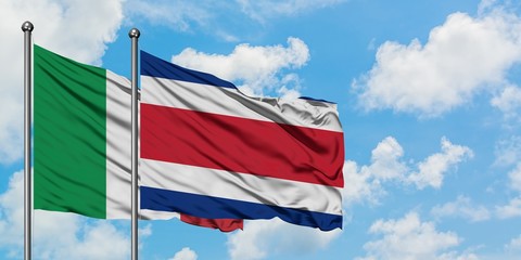 Italy and Costa Rica flag waving in the wind against white cloudy blue sky together. Diplomacy concept, international relations.