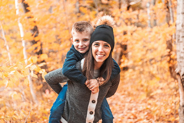 A portrait of a mother with child in the autumn park