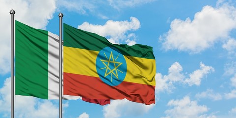 Italy and Ethiopia flag waving in the wind against white cloudy blue sky together. Diplomacy concept, international relations.