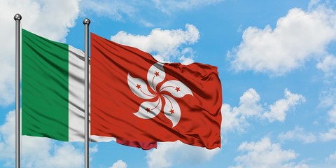 Italy and Hong Kong flag waving in the wind against white cloudy blue sky together. Diplomacy concept, international relations.