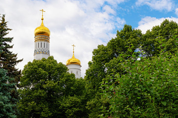 Fototapeta na wymiar View of the bell Ivan the Great Bell Tower in the Moscow Kremlin, hidden behind the trees