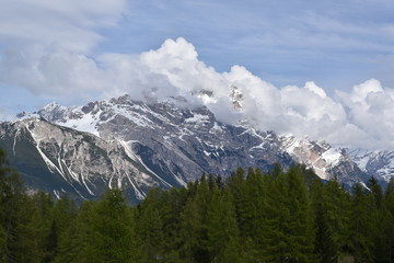 Mountains  with forest in spring in Dolomites with blue sky and clouds