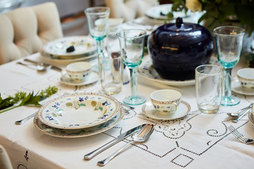 Beautifully decorated table set with flowers, candles, plates and serviettes for wedding or another event in the restaurant.
