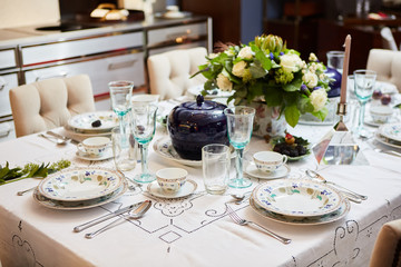 Beautifully decorated table set with flowers, candles, plates and serviettes for wedding or another event in the restaurant.