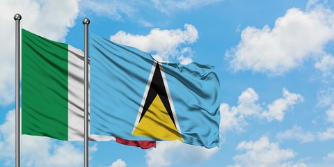 Italy and Saint Lucia flag waving in the wind against white cloudy blue sky together. Diplomacy concept, international relations.