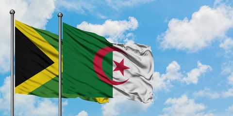 Jamaica and Algeria flag waving in the wind against white cloudy blue sky together. Diplomacy concept, international relations.