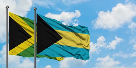 Jamaica and Bahamas flag waving in the wind against white cloudy blue sky together. Diplomacy concept, international relations.