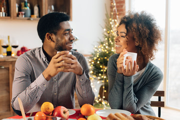 Young couple drinking coffee and enjoying Christmas morning