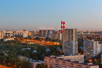 Aerial view to the city skyline at evening hours. Sleeping area and power plant on sunset background