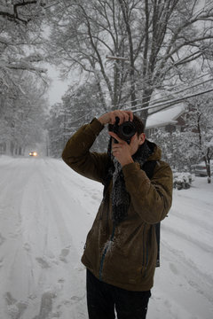 Man taking pictures in the snow