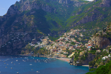 Obraz na płótnie Canvas One of the best resorts of Italy with old colorful villas on the steep slope, nice beach, numerous yachts and boats in harbor and medieval towers along the coast, Positano.