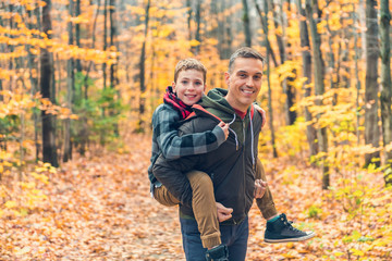 A portrait of a father with child in the autumn park