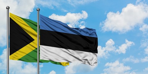 Jamaica and Estonia flag waving in the wind against white cloudy blue sky together. Diplomacy concept, international relations.