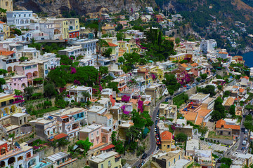 Naklejka premium One of the best resorts of Italy with old colorful villas on the steep slope, nice beach, numerous yachts and boats in harbor and medieval towers along the coast, Positano.