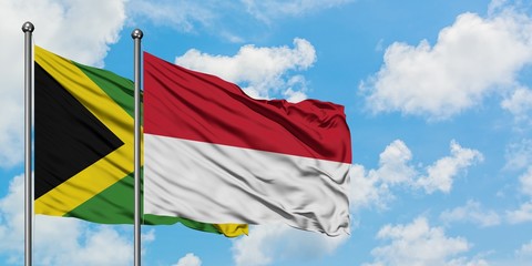 Jamaica and Indonesia flag waving in the wind against white cloudy blue sky together. Diplomacy concept, international relations.