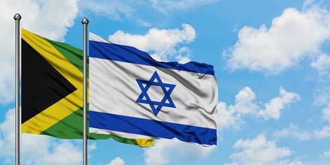 Jamaica and Israel flag waving in the wind against white cloudy blue sky together. Diplomacy concept, international relations.