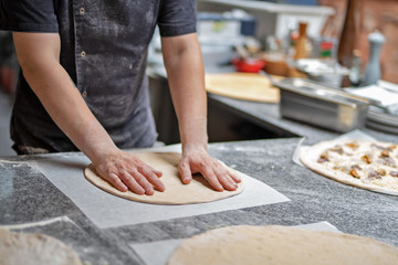 Obraz na płótnie Canvas Chef preparing pizza dough, close-up. Pizzeria, Italian cuisine