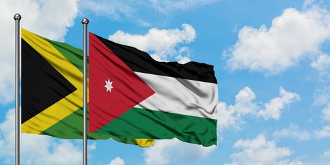 Jamaica and Jordan flag waving in the wind against white cloudy blue sky together. Diplomacy concept, international relations.