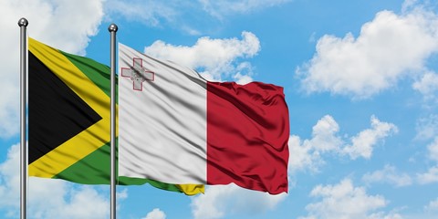 Jamaica and Malta flag waving in the wind against white cloudy blue sky together. Diplomacy concept, international relations.