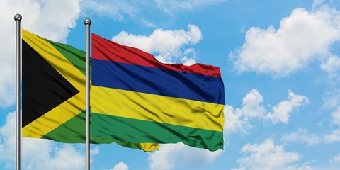 Jamaica and Mauritius flag waving in the wind against white cloudy blue sky together. Diplomacy concept, international relations.