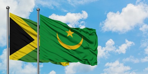 Jamaica and Mauritania flag waving in the wind against white cloudy blue sky together. Diplomacy concept, international relations.