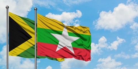 Jamaica and Myanmar flag waving in the wind against white cloudy blue sky together. Diplomacy concept, international relations.