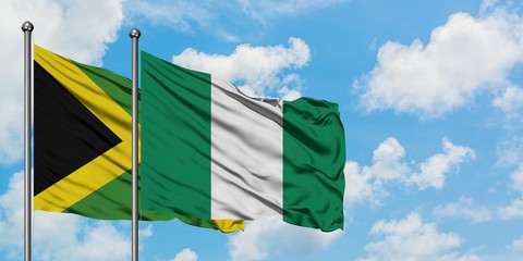 Jamaica and Nigeria flag waving in the wind against white cloudy blue sky together. Diplomacy concept, international relations.