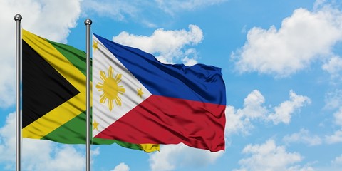 Jamaica and Philippines flag waving in the wind against white cloudy blue sky together. Diplomacy concept, international relations.