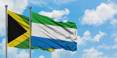 Jamaica and Sierra Leone flag waving in the wind against white cloudy blue sky together. Diplomacy concept, international relations.
