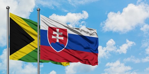 Jamaica and Slovakia flag waving in the wind against white cloudy blue sky together. Diplomacy concept, international relations.