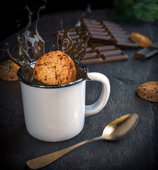 Chocolate chip cookie falling on the cup, chocolate splash, gradient background chocolate and cookie tablet