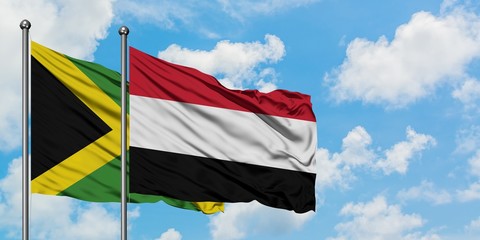 Jamaica and Yemen flag waving in the wind against white cloudy blue sky together. Diplomacy concept, international relations.