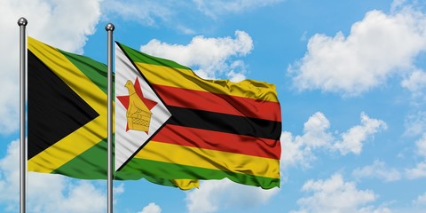Jamaica and Zimbabwe flag waving in the wind against white cloudy blue sky together. Diplomacy concept, international relations.