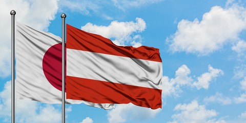 Japan and Austria flag waving in the wind against white cloudy blue sky together. Diplomacy concept, international relations.