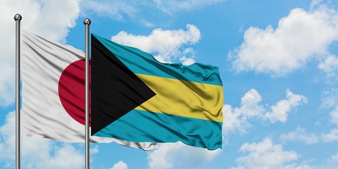 Japan and Bahamas flag waving in the wind against white cloudy blue sky together. Diplomacy concept, international relations.