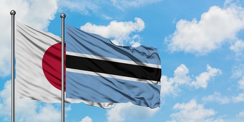 Japan and Botswana flag waving in the wind against white cloudy blue sky together. Diplomacy concept, international relations.