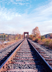 Fototapeta na wymiar Railroad Bridge on the Connecticut River with Fall Foliage All Around