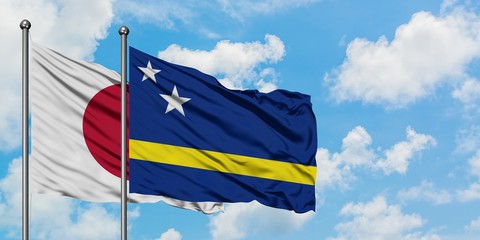 Japan and Curacao flag waving in the wind against white cloudy blue sky together. Diplomacy concept, international relations.
