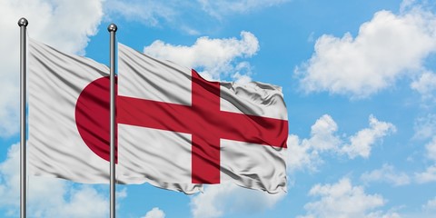 Japan and England flag waving in the wind against white cloudy blue sky together. Diplomacy concept, international relations.