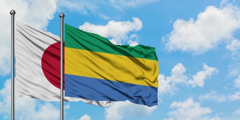 Japan and Gabon flag waving in the wind against white cloudy blue sky together. Diplomacy concept,...